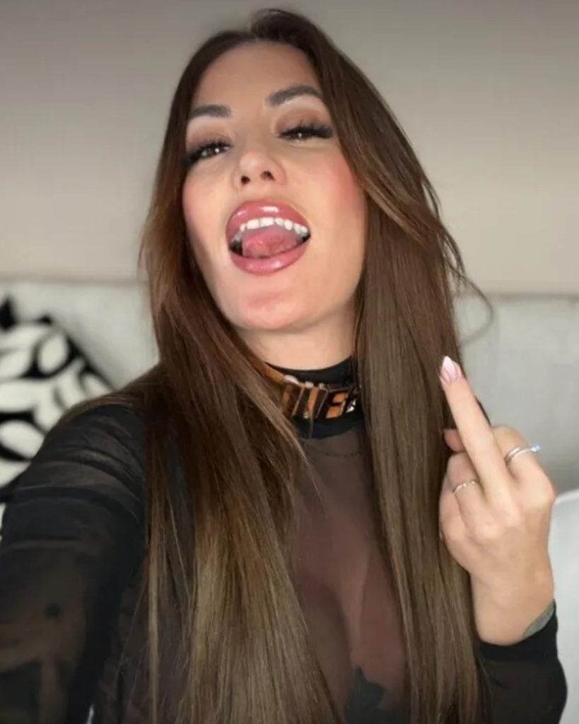 Woman with brown hair making a middle finger gesture.