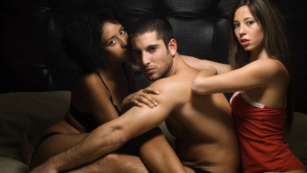 Intimate portrait of three people against a dark backdrop.