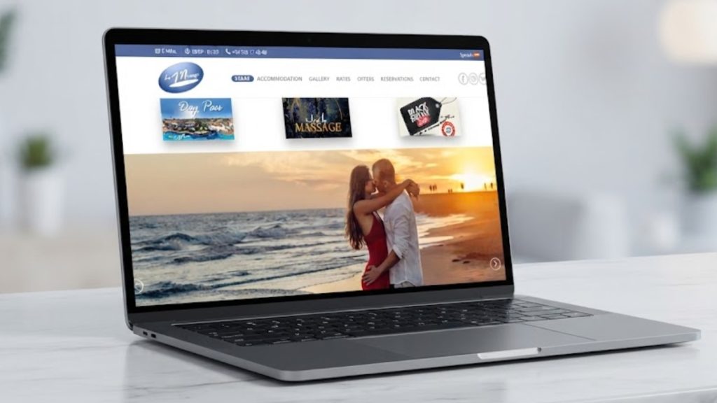 Laptop displaying a beach resort website on a white desk.