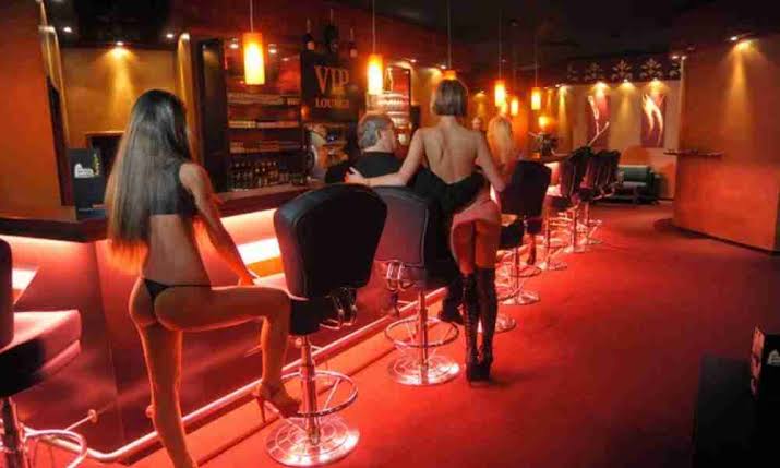 Dimly lit VIP lounge with women sitting at the bar.
