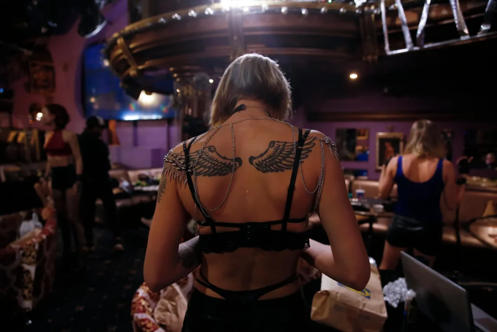 Back view of woman with wing tattoos and silver chains.