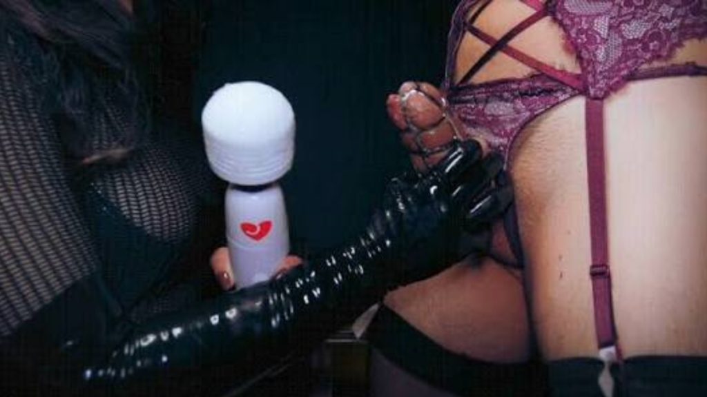 Person in latex glove holding vibrator near purple lingerie.