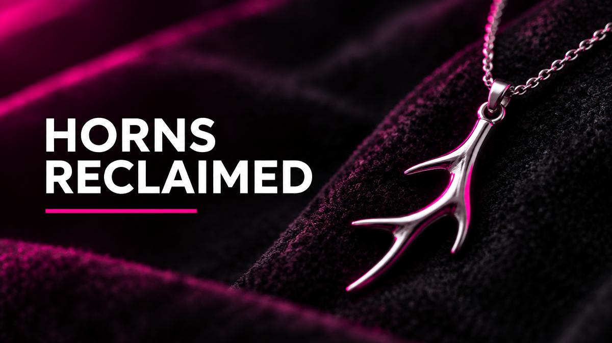 Silver stag antler pendant on charcoal velvet under hot pink light, representing how the modern stag and hotwife community reclaimed the cuckold horns symbol.