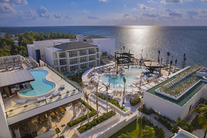 Aerial view of The Eden section at Desire Riviera Maya with swim-up suites and the Caribbean coastline