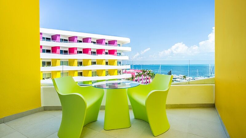 Temptation Cancun Bash Tower Ocean View room balcony with lime-green chairs facing the Caribbean