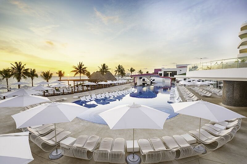 Temptation Cancun Sexy Pool at sunset with Bali beds and the top-optional main pool deck