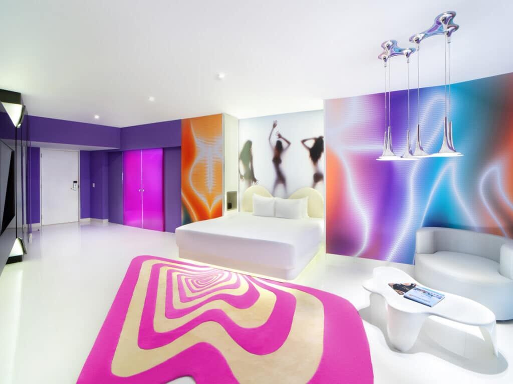 Temptation Cancun Lush Tower Oceanfront Suite with pink swirl rug and Karim Rashid-style mural art
