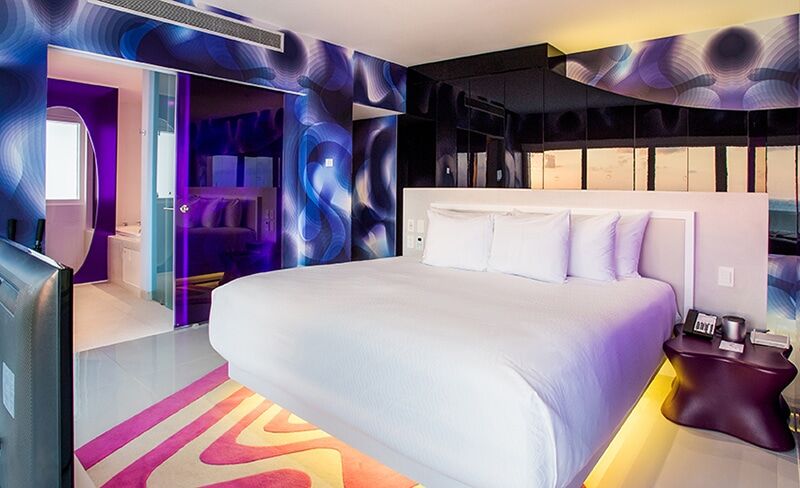 Temptation Cancun Oceanfront Master Suite bedroom in The Tower with neon-lit platform bed