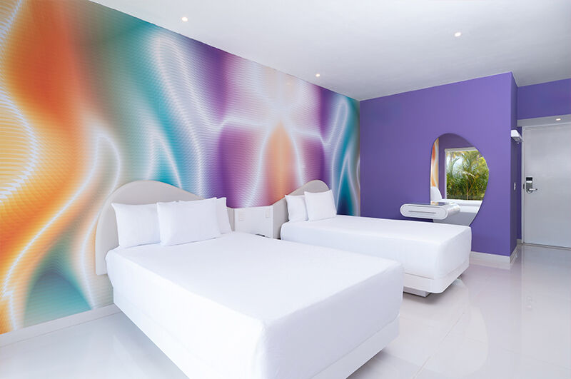 Temptation Cancun Trendy Ocean View room with white king bed and purple accent wall