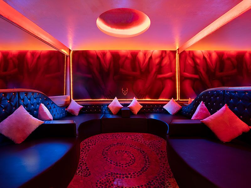 Desire Pearl Playroom lounge with red lighting and curved sofas, a couples-only space at the adults-only resort