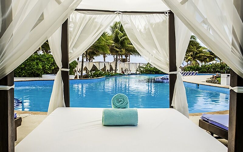 Desire Pearl clothing-optional main pool seen from a curtained Bali bed